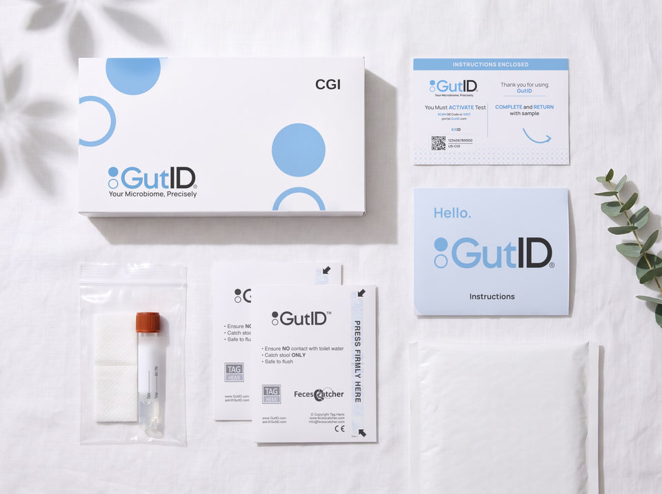 The GutID kit laid out: the box, the activation card, the instructions, the prepaid return mailer, two FecesCatcher stool collectors, and the collection tube in its clear sample bag